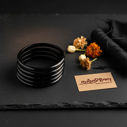 Nattrinai Karuppu Valaiyal traditional black bangles arranged on dark wooden surface with brand tag placed flat beside them