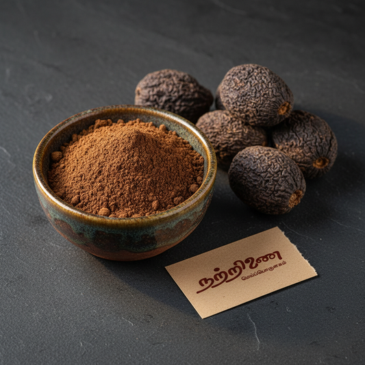 Nattrinai Kadukkai powder in a ceramic bowl with whole dried Kadukkai fruits on dark slate surface with brand tag placed flat beside it